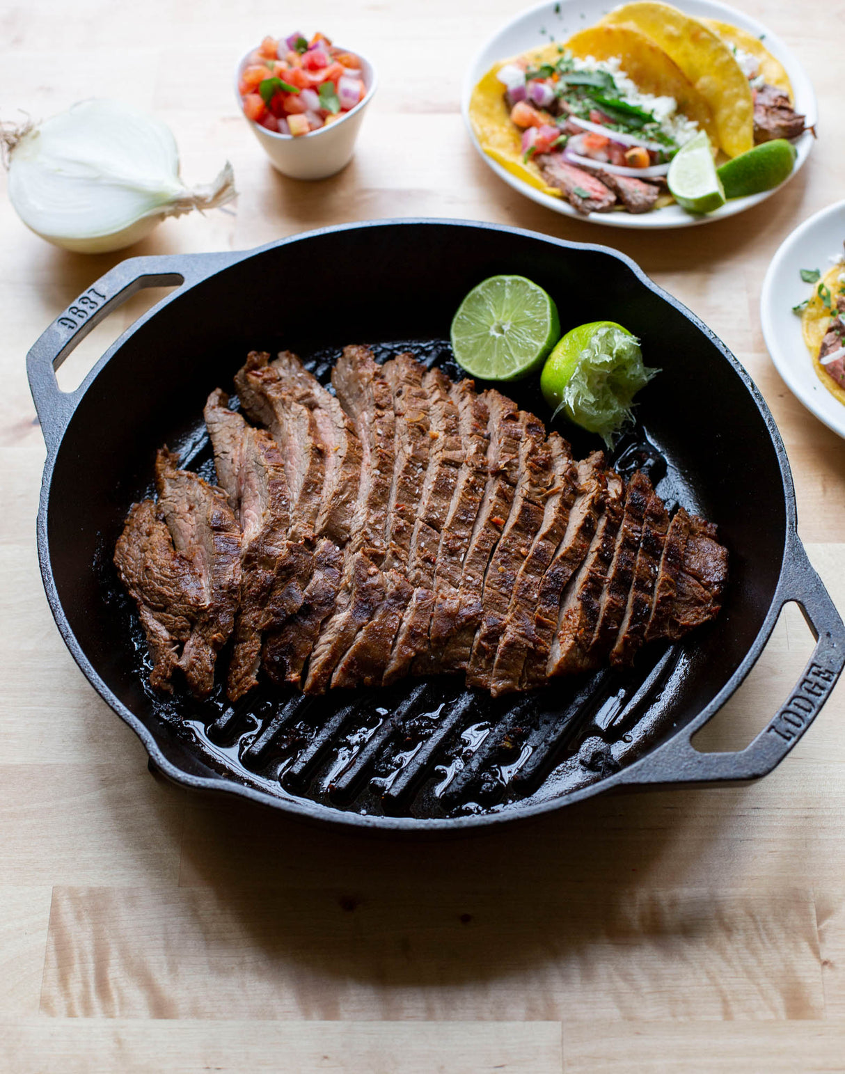 Schwarze LODGE Grillpfanne mit Doppelgriff und klassischem Design, ideal für Grillgerichte auf offener Flamme.