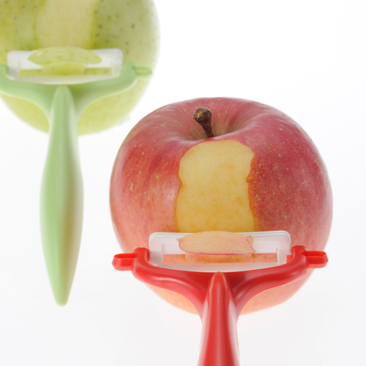 KYOCERA Schäler mit doppelseitigem Schliff in Grün, ideal zum schnellen Schneiden von Gemüse und Obst.