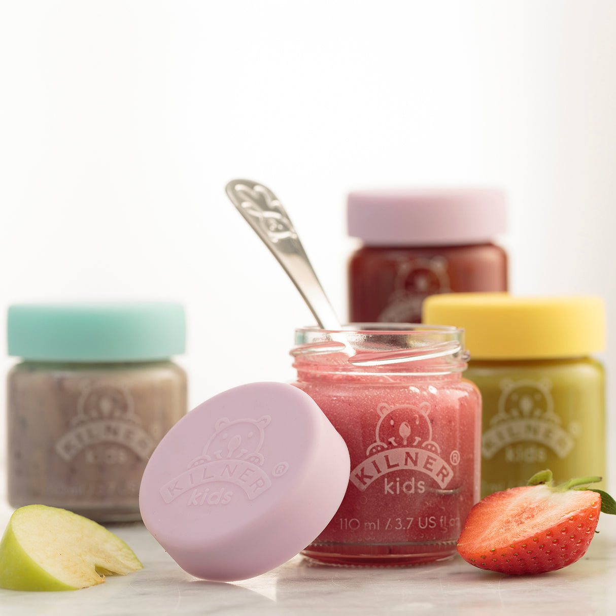Bunte KILNER Babygläser in klarer Ausführung, mit bunten Deckeln, für Babysnacks oder Aufbewahrung, auf weißem Hintergrund.