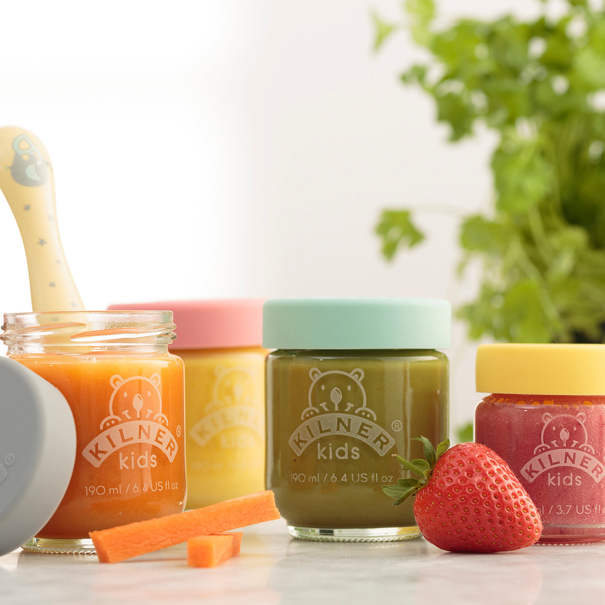 Bunte KILNER Babygläser in Klar mit bunten Deckeln, ideal für Babyfutter und Snacks, auf weißem Hintergrund.