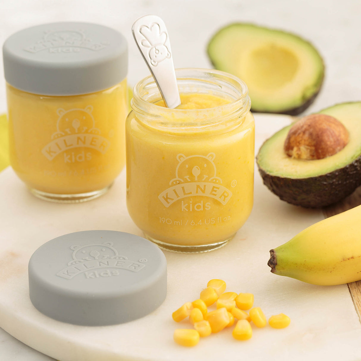 Bunte KILNER Babygläser aus Glas, klar mit bunten Deckeln, ideal für Babynahrung und Snacks.