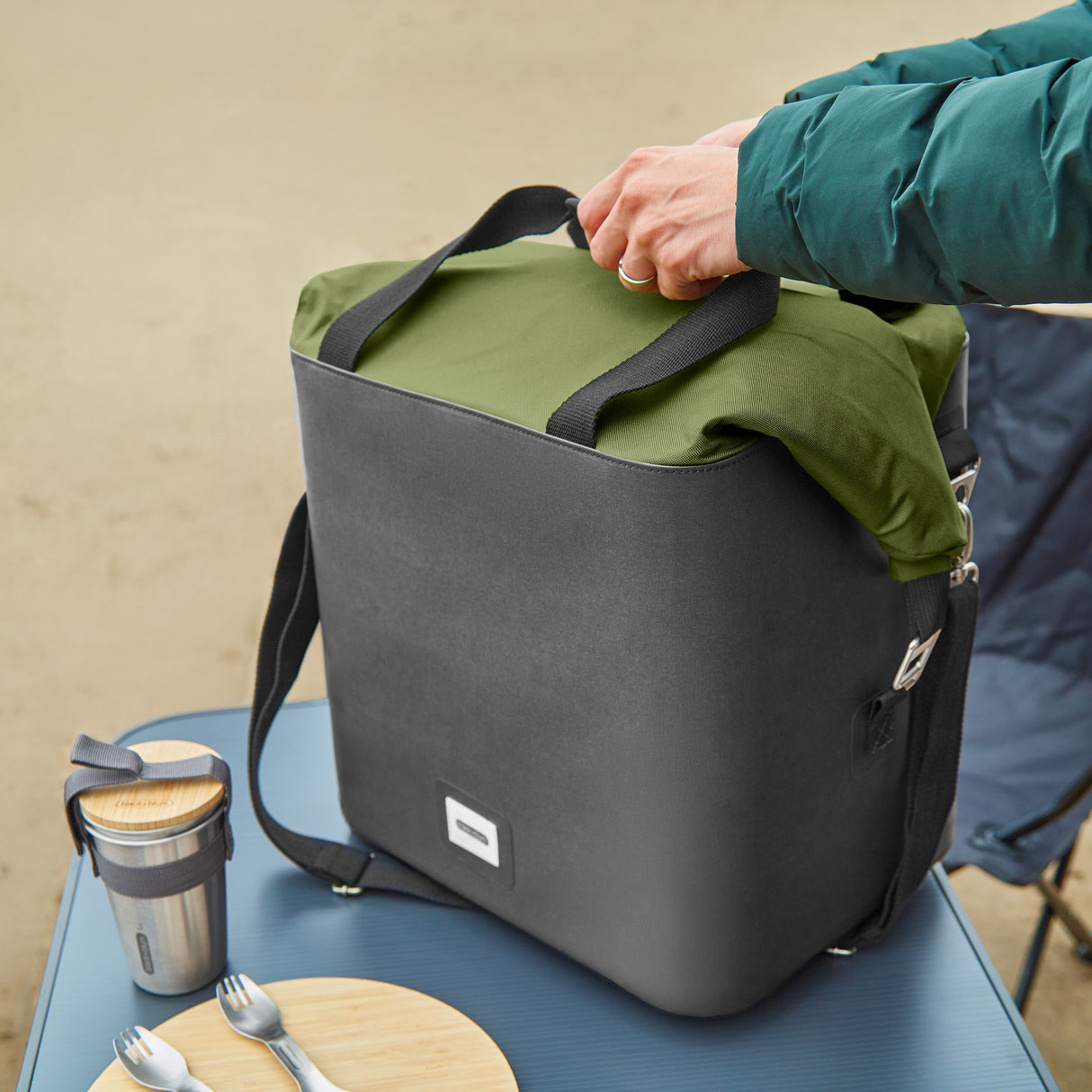 Schwarz-grüne faltbare Kühltasche von BLACK+BLUM mit isolierter Innenausstattung für Kühlgut am Strand.