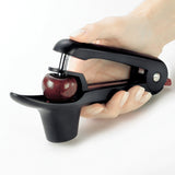 Schwarzer CUISIPRO Kirsch- und Olivenentkerner mit ergonomischem Griff, zum Entfernen von Kernen aus Früchten.