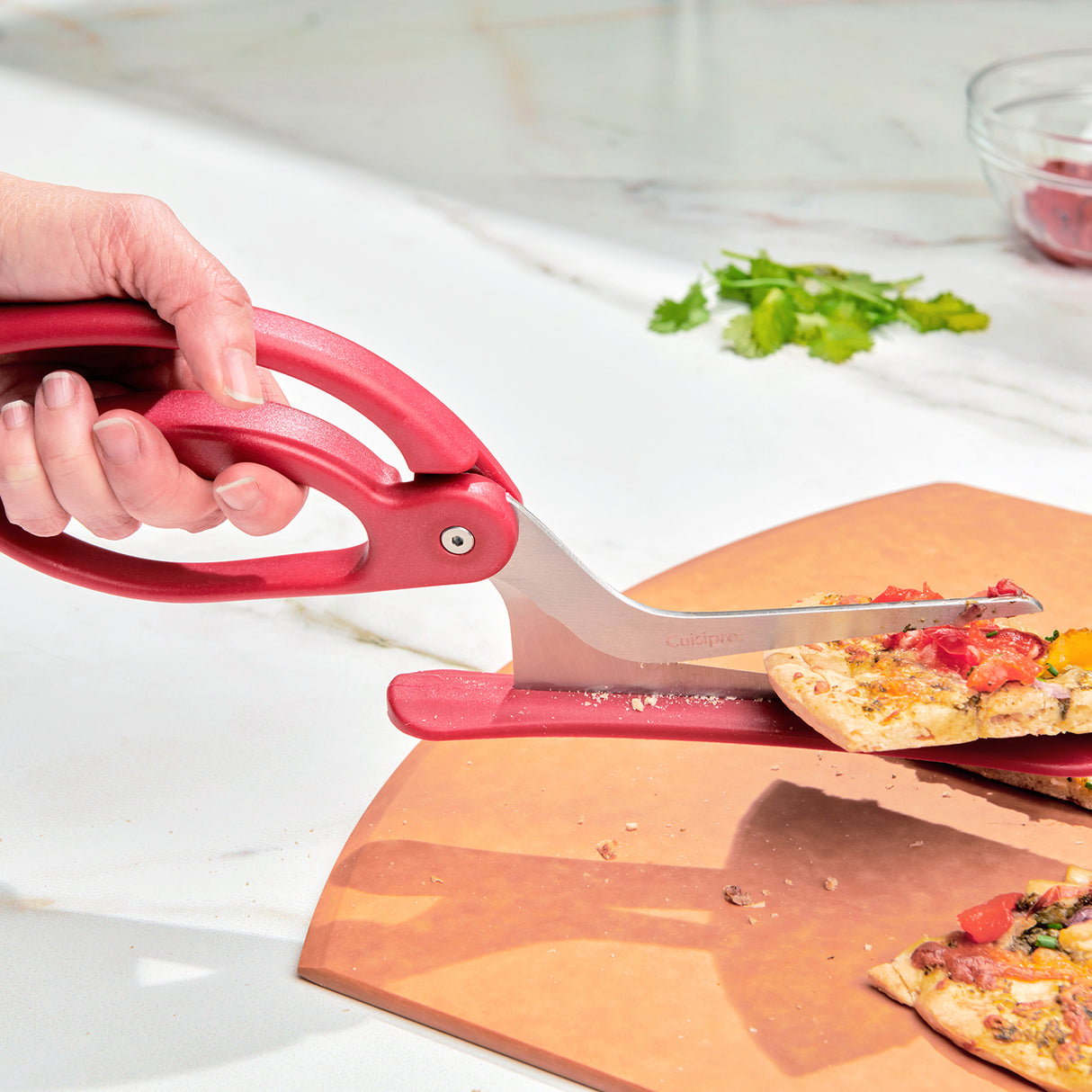 Rote CUISIPRO Pizzaschere mit Edelstahlklinge zum sauberen Schneiden von Pizza, Nahaufnahme.