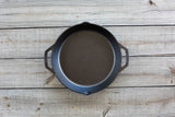 Schwarze Gusseiserne Pfanne von LODGE, Classic-Serie, mit runder Form und stabilem Griff, zum Kochen und Braten.