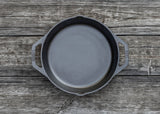 Schwarze LODGE Gusseiserne Pfanne CLASSIC mit flachem Boden und Griff, ideal zum Braten und Kochen in der Küche.