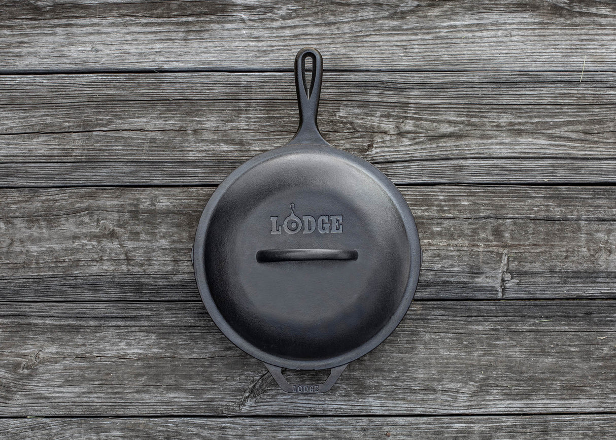 Schwarzer LODGE Deckel für Kochgeschirr, klassische runde Form, aus langlebigem Material, auf einem Herd displayt.