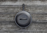 Schwarzer LODGE Deckel für Kochgeschirr, klassische runde Form, aus langlebigem Material, auf einem Herd displayt.