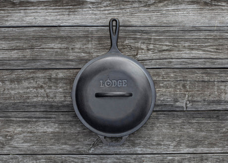 Schwarzer LODGE Deckel für Kochgeschirr, klassische runde Form, aus langlebigem Material, auf einem Herd displayt.