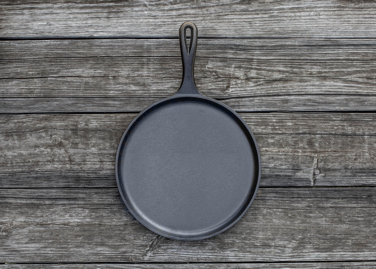 Schwarze flache Grillpfanne von LODGE, Ø 26 cm, aus robustem Material, ideal zum Grillen und Braten.