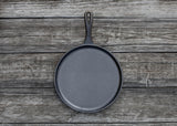 Schwarze flache Grillpfanne von LODGE, Ø 26 cm, aus robustem Material, ideal zum Grillen und Braten.