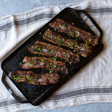 Lodge Grillplatte, zweiseitig glatt und gerillt, Kochplatte für Grill und Pfanne, robuste Eisenpfanne in Nahaufnahme