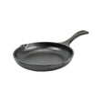 Schwarze LODGE Gusseiserne Pfanne für Kochen und Braten, mit ergonomischem Griff, auf Kochplatte liegend.