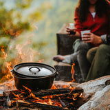 Schwarzer Lodge Classic Grill aus Gusseisen mit Holzgriff, ideal zum Grillen im Freien, auf einer Terrasse.
