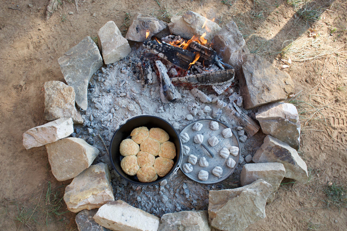 Schwarzer LODGE Grill Classic aus Gusseisen mit Deckel und Griffe, ideal für Grillgerichte und BBQ.