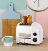 Weißer DUALIT Toaster NEWGEN mit 2 Toastscheiben, modernes Design und einfache Bedienung, auf einem Küchenarbeitsplatz.