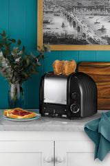 Schwarzer DUALIT Toaster NEWGEN mit 2 Toastscheiben, modernes Design und Bedienfeld sichtbar.