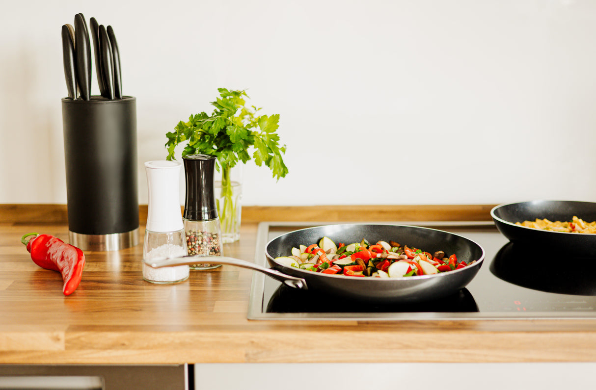 Schwarze KYOCERA Keramikpfanne mit glatter Oberfläche, ideal für gesundes Kochen und gleichmäßige Hitzeverteilung
