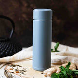 Weiße KYOCERA Isolierflasche SLIM MUG mit Edelstahlverschluss, schlankes Design und auslaufsicher für unterwegs.