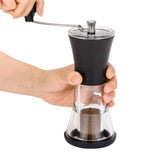 Schwarze KYOCERA Keramik-Kaffeemühle mit Deckel, die Mahlwerk und Griff zeigt.