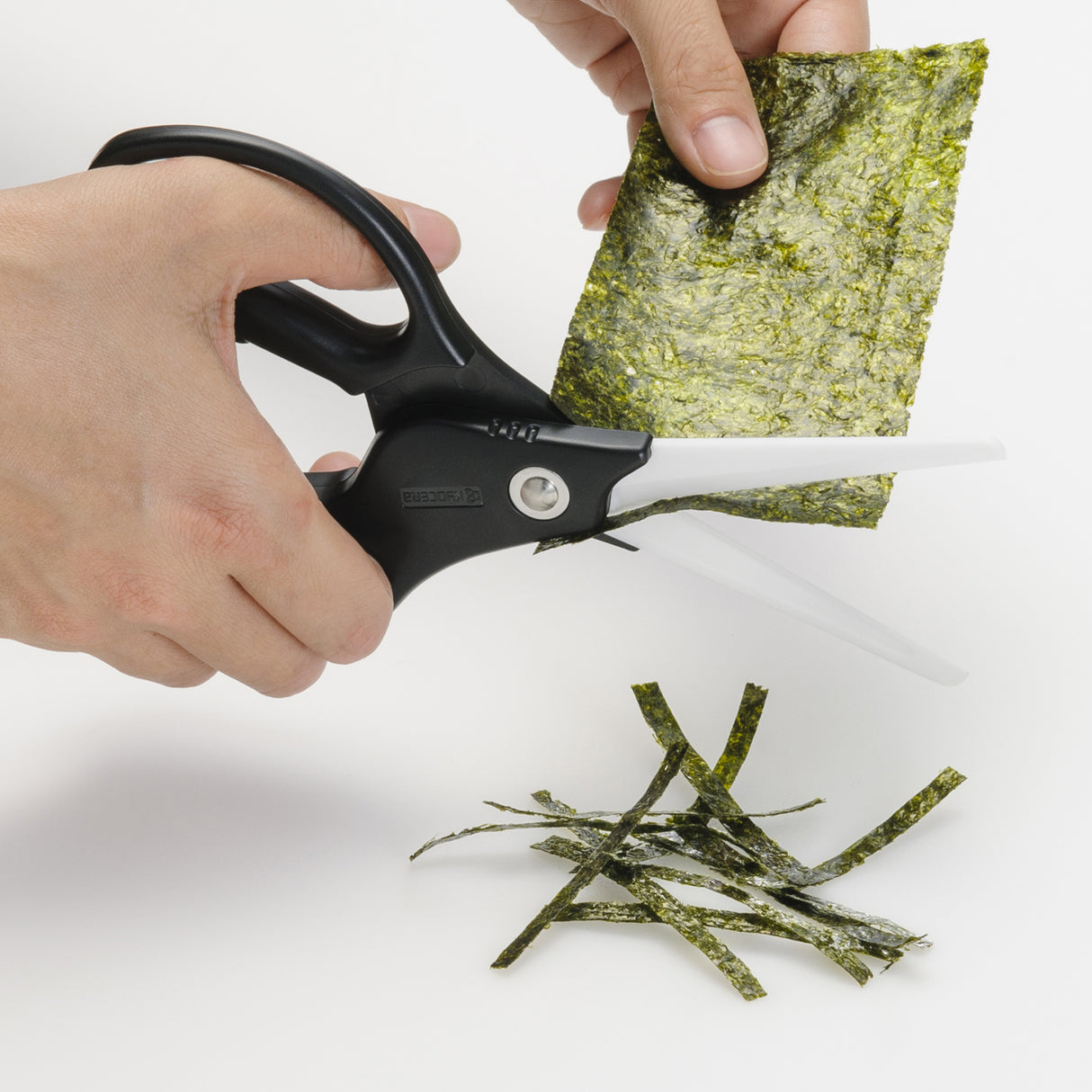 Schwarze und weiße KYOCERA Keramik-Küchenschere mit Kunststoffgriffen, ideal zum Schneiden in der Küche