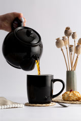Schwarze Teekanne von PRICE & KENSINGTON aus Keramik, stilvolles Design für Teeliebhaber, auf weißem Hintergrund.