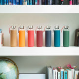 Schwarz-orange Glas-Wasserflasche von black+blum, 600 ml, mit Trinkverschluss und transparentem Design.