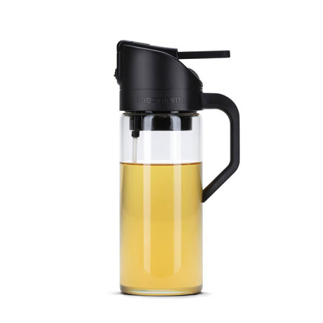 Schwarze DREAMFARM Ölsprüh-Flasche OILEROO, 400 ml, aus Kunststoff, für Öl- und Essigsprühungen, auf einer Küchenarbeitsfläche.