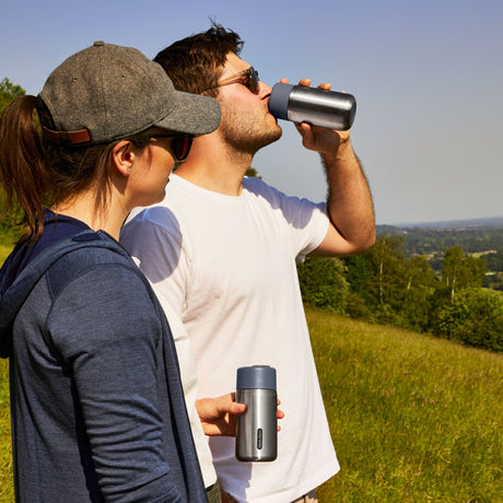 Schwarzer BLACK+BLUM Thermobecher im Hike-Design, isoliert, 340 ml, orange, für unterwegs, mit Deckel und Griff.
