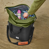 Faltbare, schwarze Kühlbox von BLACK+BLUM mit isolierter Innenausstattung, offen auf einem Strand.