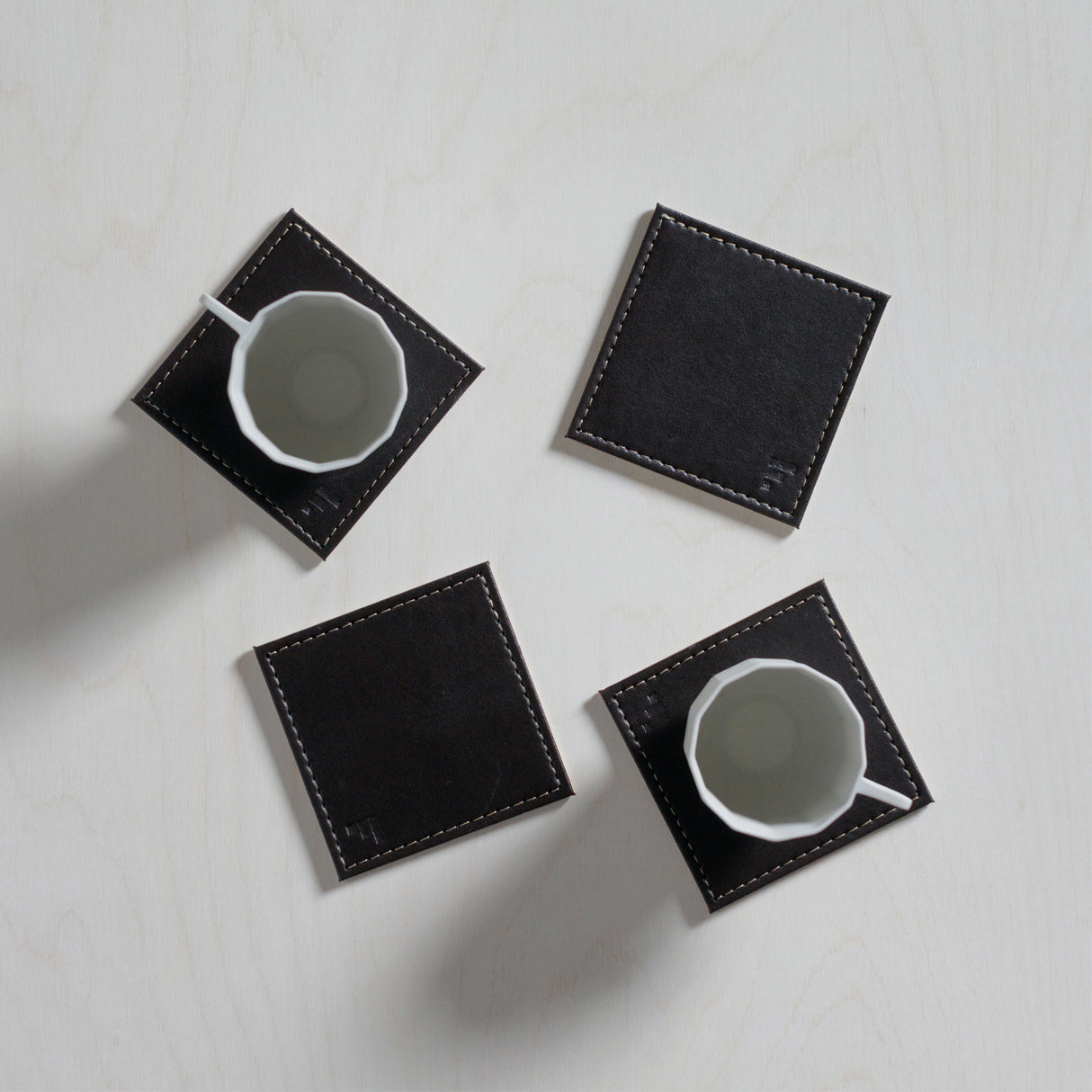Vier kostenlose FREEFORM Untersetzer DUO im 4er-Set aus robustem Material, ideal zum Schutz von Tischen und Oberflächen.